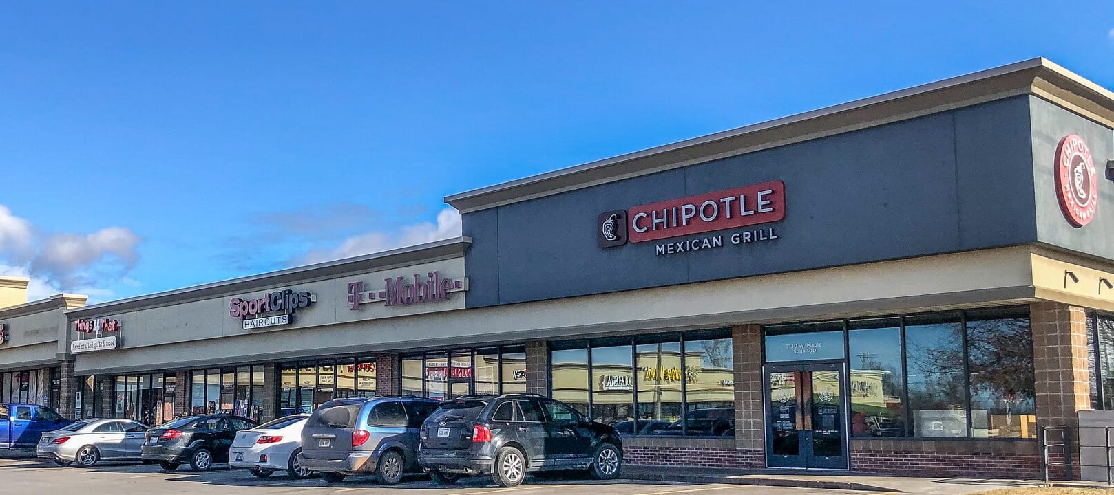 Maple Ridge Centre storefronts under a blue sky, with Chipotle and Sport Clips signs