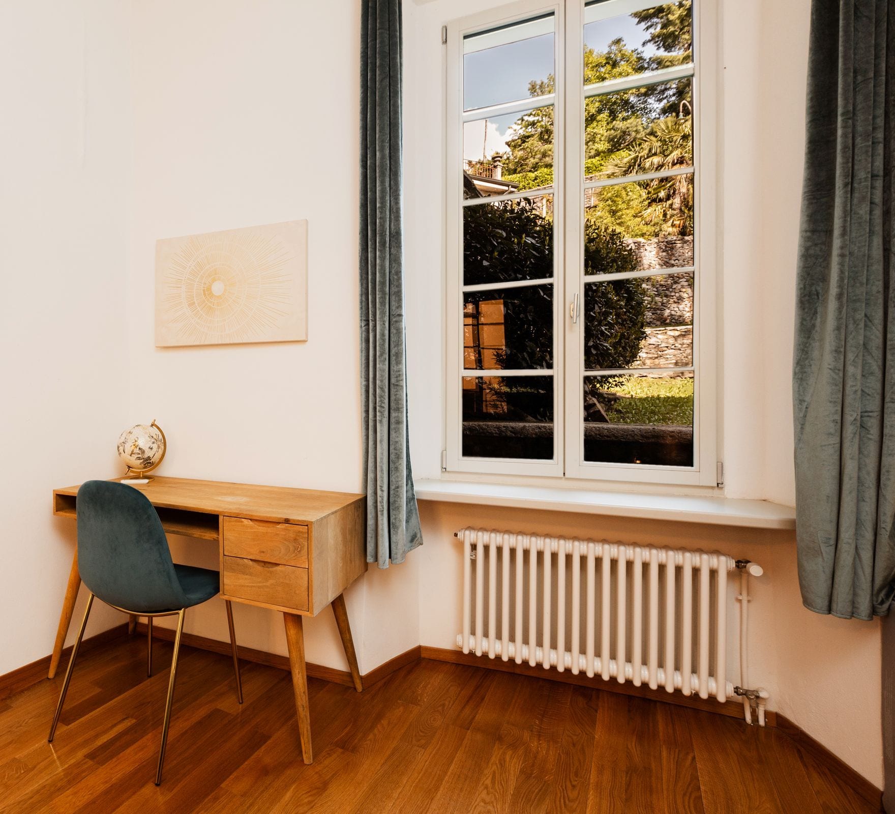 Minimal private office with a light-oak desk, teal chair and tall window